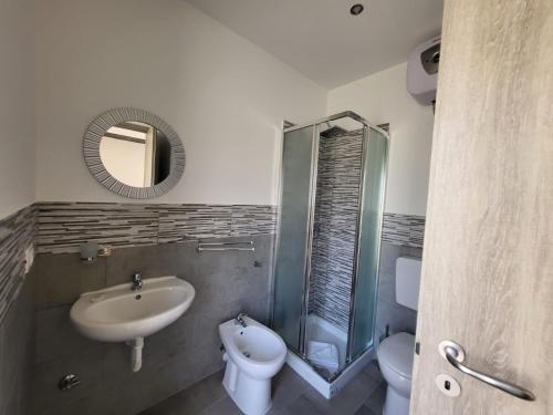 a bathroom with a sink and a toilet and a mirror at Casa Giagoni in Santa Teresa Gallura