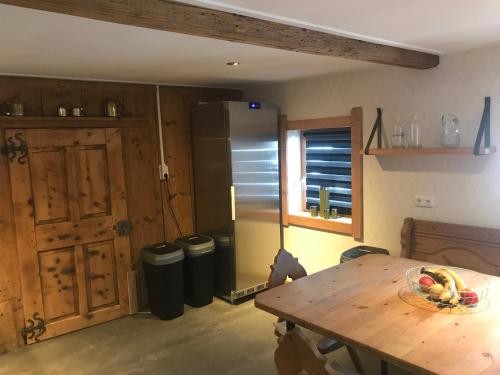 a kitchen with a wooden table and a refrigerator at The Farm in Westendorf