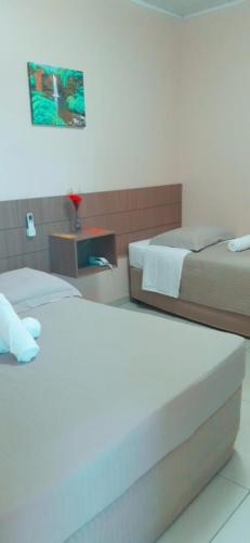 a hotel room with two beds and a table at Hotel Caroline in Timon