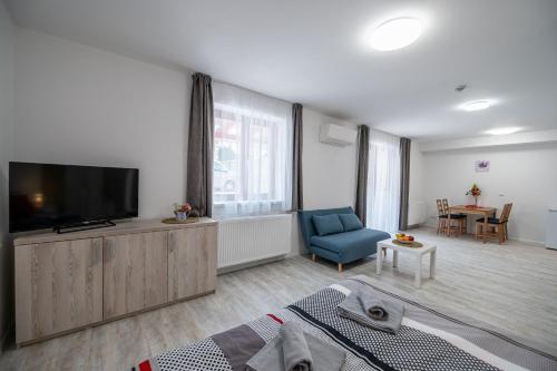 a living room with a television and a blue chair at Penzion Kamenný dvůr in Třeboň