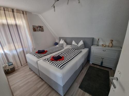 a bedroom with a bed with two red shoes on it at Ferienwohnung Söhreblick in Wattenbach