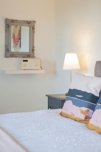 a bedroom with a bed with a mirror and a lamp at Duneden Cottage and Grounds in Randalstown