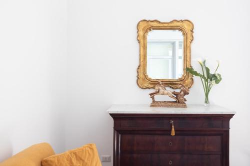 a mirror on top of a dresser in a room at Lux Aurea in Meta