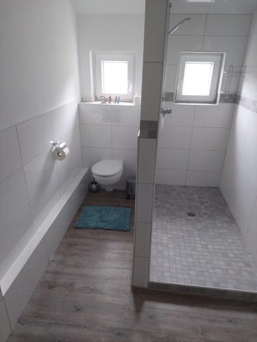 baño con aseo y ducha con 2 ventanas en Meeresleuchten, en Krummhörn