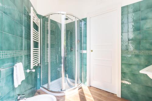 a bathroom with a shower with green tiles at Lux Aurea in Meta