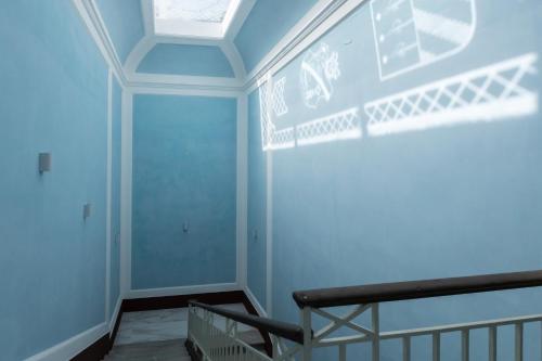 a room with a blue wall with a skylight at Lux Aurea in Meta
