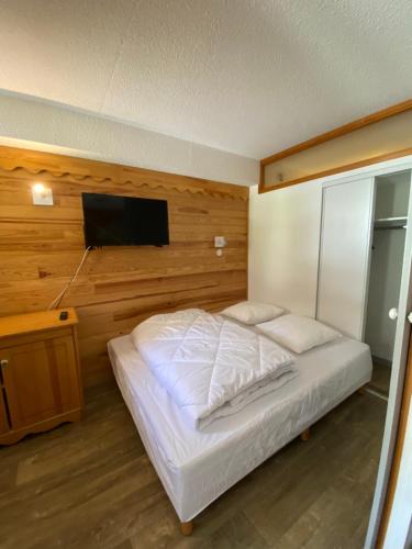Schlafzimmer mit einem Bett und einem Flachbild-TV in der Unterkunft Valmeinier 1800 - Ecrin des neiges in Valmeinier