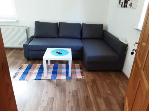 a living room with a blue couch and a table at Apartment-Ferienwohnung 3 Treffen am Ossiachersee in Treffen