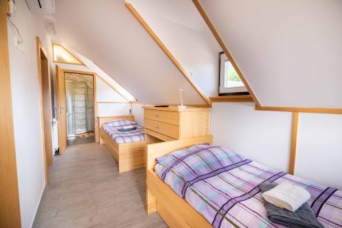 two beds in a room with a attic at Apartment & Room Pristov in Žirovnica