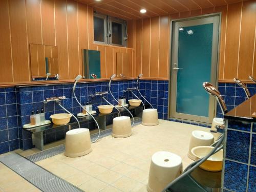 a bathroom with four sinks and a row of toilets at HOTEL ERENOA in Nagoya