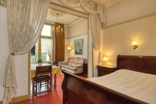 a bedroom with a bed and a chair and a table at Hotel Pension 't Huys Grol in Renesse