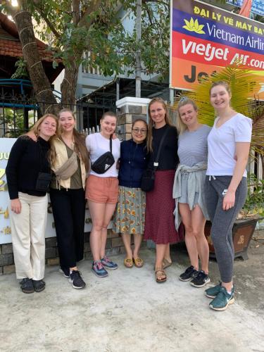 a group of women standing in front of a sign at Cheerful Hoi An Hostel in Hoi An