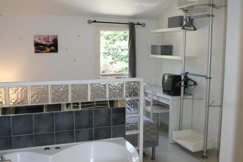 La salle de bains est pourvue d'un lavabo blanc et d'un bureau. dans l'établissement Coquet appartement dans mazet Ste Maxime Riviera, à Sainte-Maxime