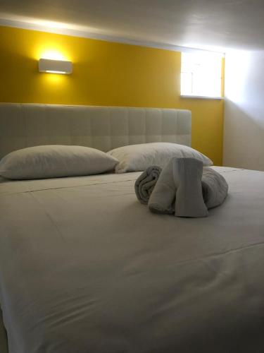 a large white bed with two towels on it at Dependance Oscar in Carrozziere
