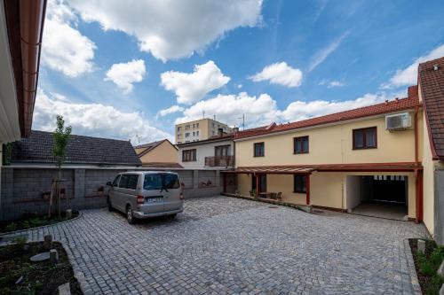 a van parked in a parking lot next to a house at Penzion Kamenný dvůr in Třeboň