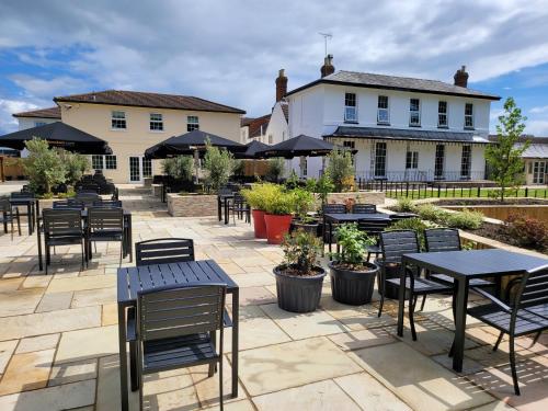 a patio with tables and chairs in front of a building at The Oakwood Hotel in Gloucester