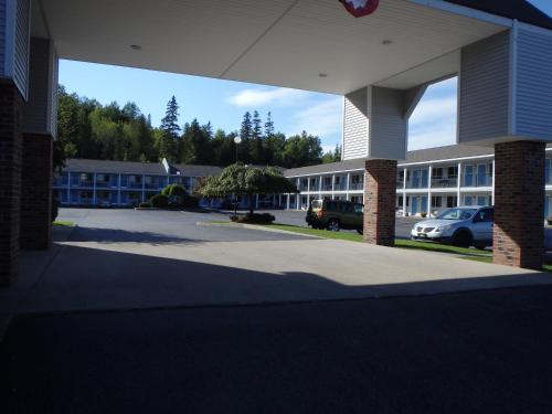 a large building with cars parked in a parking lot at Americas Best Value Inn Saint Ignace in Saint Ignace