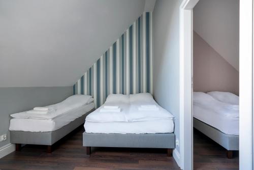 2 camas individuales en una habitación con escalera en W Starym Porcie Krynica Morska domek z widokiem na Zalew Wiślany, en Krynica Morska