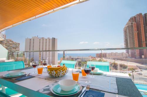 a table with glasses of wine on a balcony at Waves apartment - relax in Costa Blanca in Benidorm