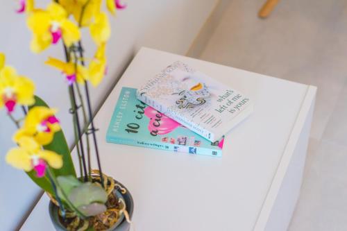 a book sitting on a table next to a vase with flowers at Waves apartment - relax in Costa Blanca in Benidorm