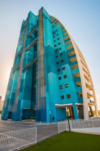 a large blue building with a curved roof at Waves apartment - relax in Costa Blanca in Benidorm