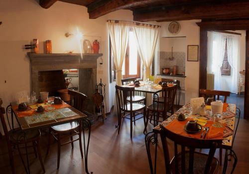 ein Esszimmer mit Tischen, Stühlen und einem Kamin in der Unterkunft Il Tomolo in Agnone