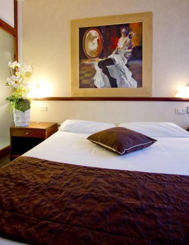 a bed in a hotel room with a painting on the wall at Green Hotel in Vergiate
