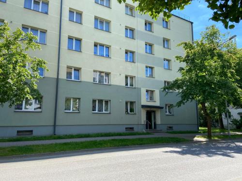 a large white building with trees in front of it at WILLOW apartamenti in Liepāja
