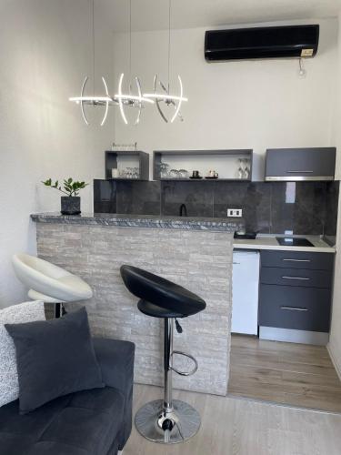 a kitchen with a counter and a bar with a stool at Apartmani Andric in Trebinje