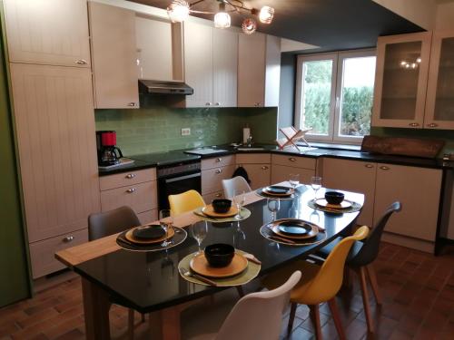 a kitchen with a dining table with chairs and a tableasteryasteryasteryasteryastery at Là ou je t 'amènerai in Gedinne