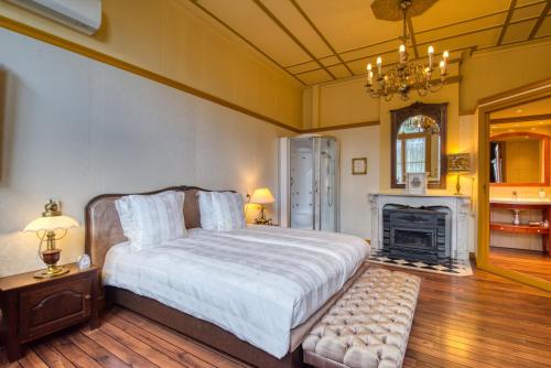 ein Schlafzimmer mit einem großen Bett und einem Kamin in der Unterkunft Hotel Pension 't Huys Grol in Renesse