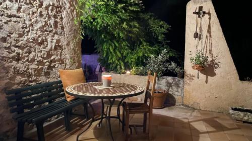 een tafel en stoelen op een patio met een kaars bij La Bastide, au cœur de la Provence in Sainte-Anastasie-sur-Issole