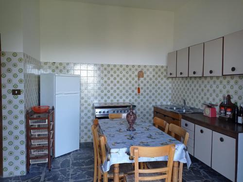 een keuken met een tafel met stoelen en een koelkast bij Casa vacanze Staiti 