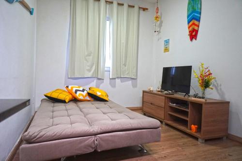 - une petite chambre avec un lit et une télévision dans l'établissement Martinica24D - Lindo apartamento a 800m PRAIA da MARTIM DE SÁ e PRAINHA - Wi-fi e Petfriendly, à Caraguatatuba