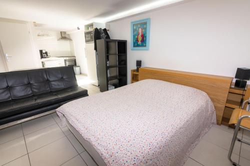 a bedroom with a bed and a couch at LE STUDIO SELESTADIEN in Sélestat