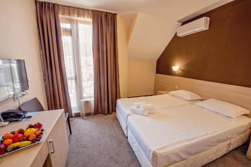 a hotel room with a bed and a bowl of fruit at Hotel Santa Maria in Obzor