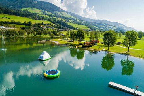 a boat in a lake with mountains in the background at Hotel in the HEART of the Alps in Uttendorf