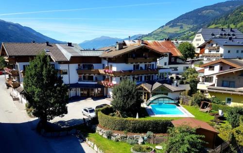 a resort with a pool and mountains in the background at Hotel in the HEART of the Alps in Uttendorf
