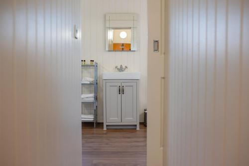 a bathroom with a sink and a mirror on the wall at Hencote Vineyard Glamping Village in Shrewsbury