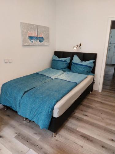 Una cama con sábanas azules y almohadas azules en un dormitorio. en City Apartment in Velbert-Mitte en Velbert