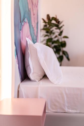 a white couch with a pillow and a plant at Hotel Majorca in Gabicce Mare