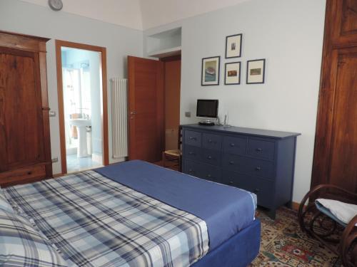 a bedroom with a bed and a dresser with a television at Apartment Alfieri in Alba