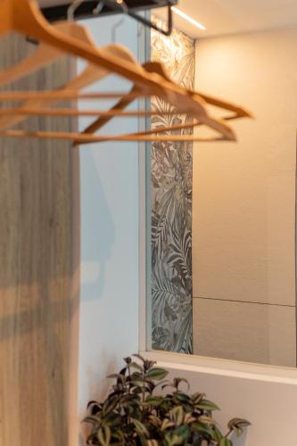 a mirror on a wall next to a plant at Hotel Majorca in Gabicce Mare
