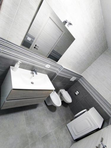 a bathroom with a sink and a toilet and a mirror at Villa Paoletti Appartamento vacanze nel cuore di Gradara in Gradara