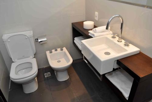uma casa de banho com um WC e um lavatório em Faros de Carrasco Apartments em Montevidéu