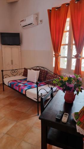 ein Wohnzimmer mit einem Sofa und einem Tisch in der Unterkunft Chez Coumbis in Gorée