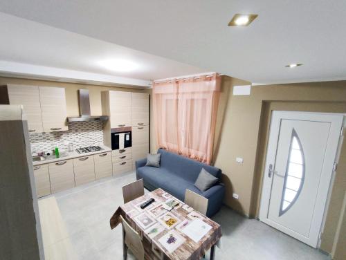 un soggiorno con divano blu e tavolo di Villa Paoletti, appartamento confortevole nel cuore di Gradara a Gradara