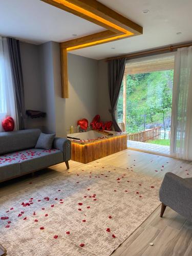 a living room with a couch and red roses on the floor at Karadeniz Suit in Rize