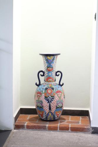 a vase sitting on top of a brick floor at Hotel Boutique Casona de Santa Clara in Puebla