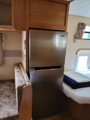 einen Kühlschrank aus Edelstahl in einem kleinen Zimmer mit einem Bett in der Unterkunft Always Summer Inn Bay Front in Culebra